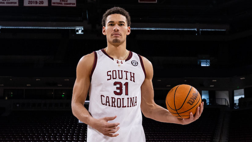 Man in garnet and while basketball jersey with South Carolina on it dunks a basketball